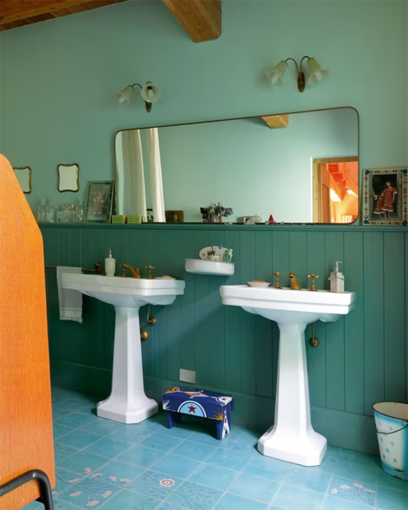Deux lavabos de style Art déco, mis en scène dans une salle de bains dans les tonalités de bleus et verts d'eau