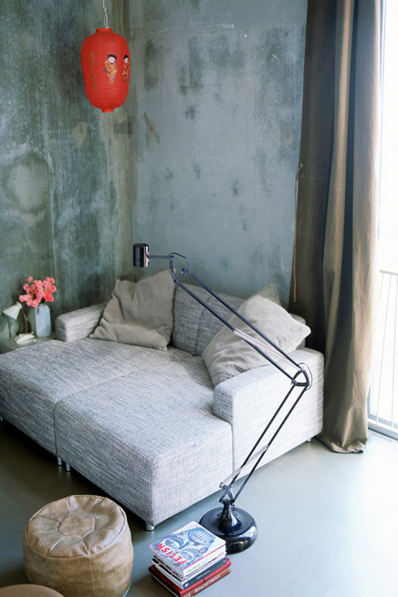Un salon aux murs en béton brut avec du mobilier design