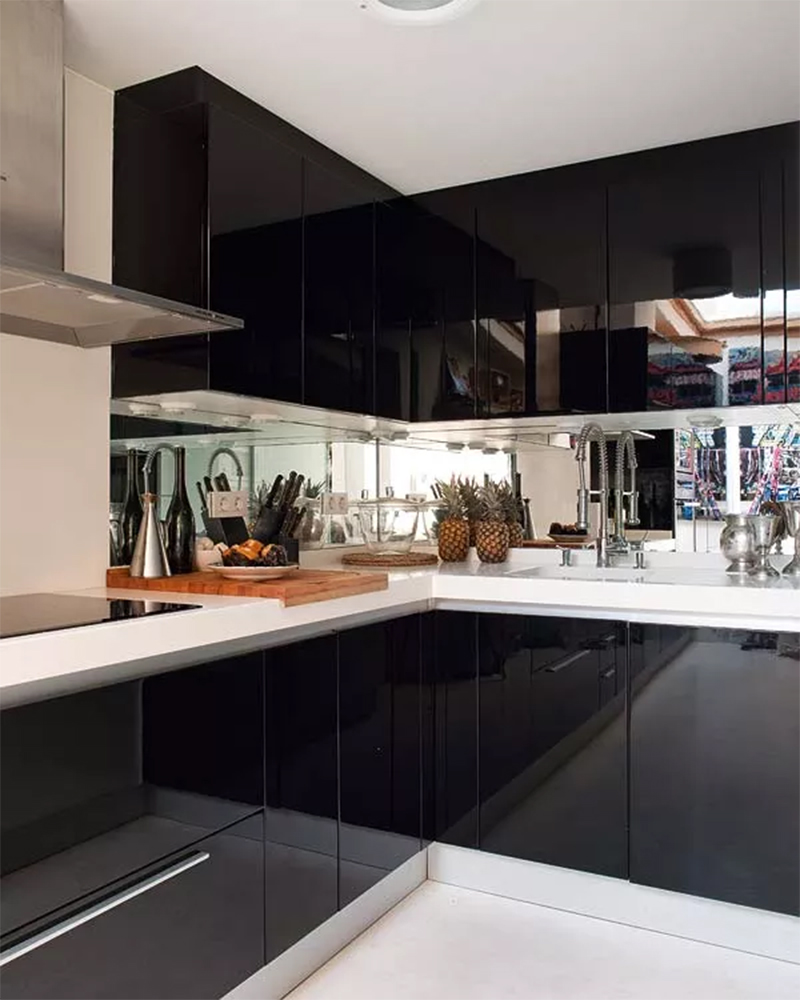 Cuisine aux placards de cuisine laqués en noir avec crédence miroir