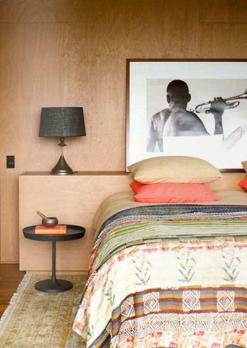 Une chambre avec une tête de lit intégrée en plywood
