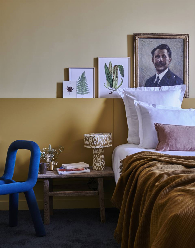 Une chambre avec un soubassement jaune ocre et un mur du haut plus clair