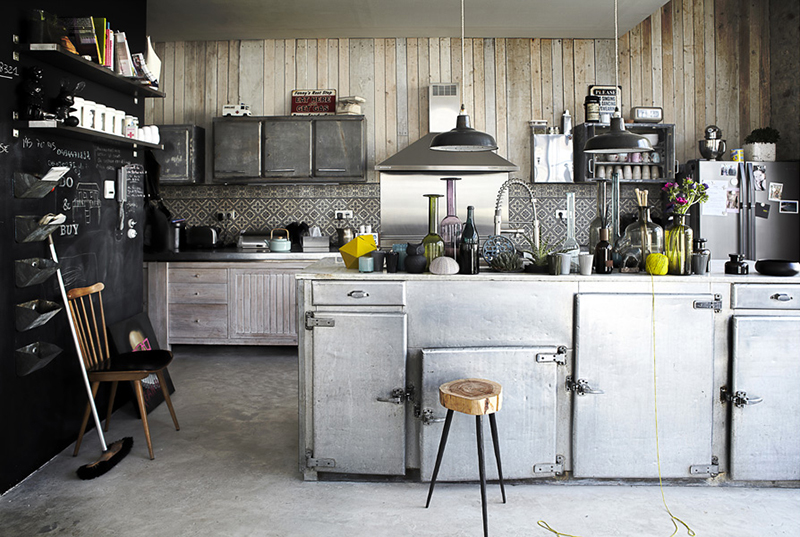 Une cuisine de style industriel avec des placards en zinc récupérés