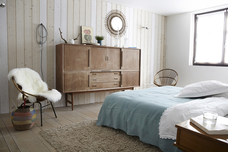 Une chambre de style scandinave avec son plancher bois et son revêtement en bois