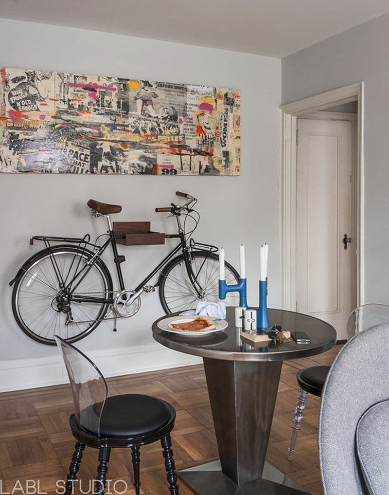Le vélo intégré comme élément de décor est suspendu au mur en dessous d'un tableau