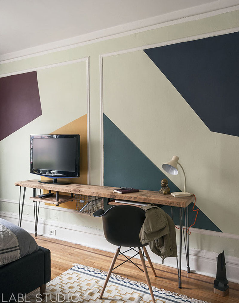 Un coin bureau réalisé avec une planche de bois brut a été placé le long du mur de la chambre