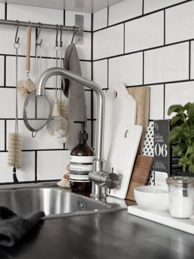 Cuisine scandinave blanche avec crédence en carreaux de faïence rectangulaires et joints noirs