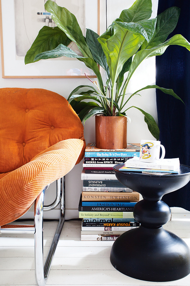 Un fauteuil vintage en velours orange et son bout de canapé noir