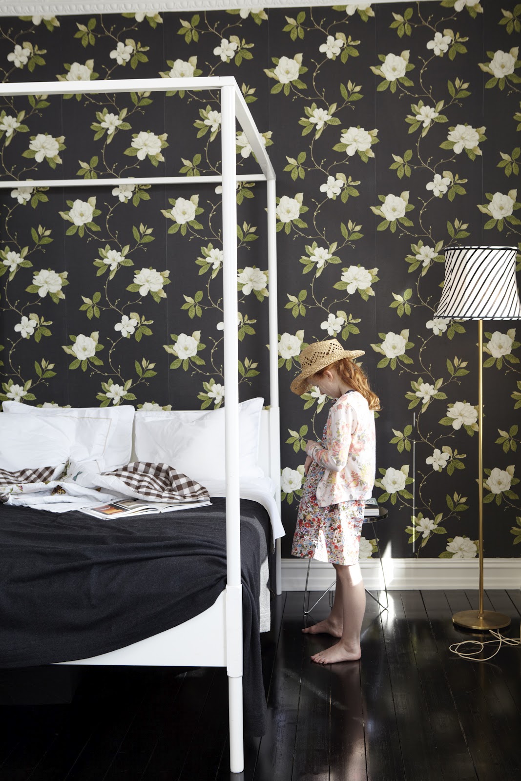 Papier peint floral sur fond noir pour cette chambre au parquet noir laqué