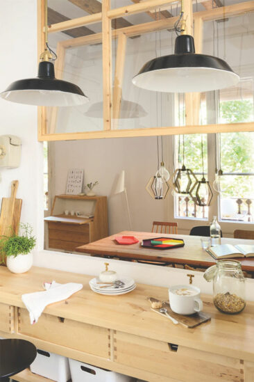 Une cuisine blanche moderne et minimaliste réchauffée par du pin et des plantes vertes