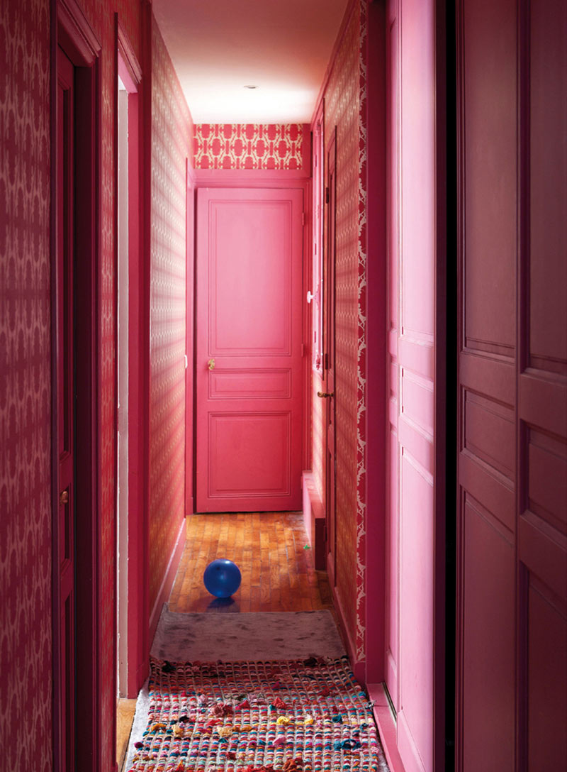 Une incroyable couloir peint d'un beau rose fuchsia, assorti au papier peint rétro