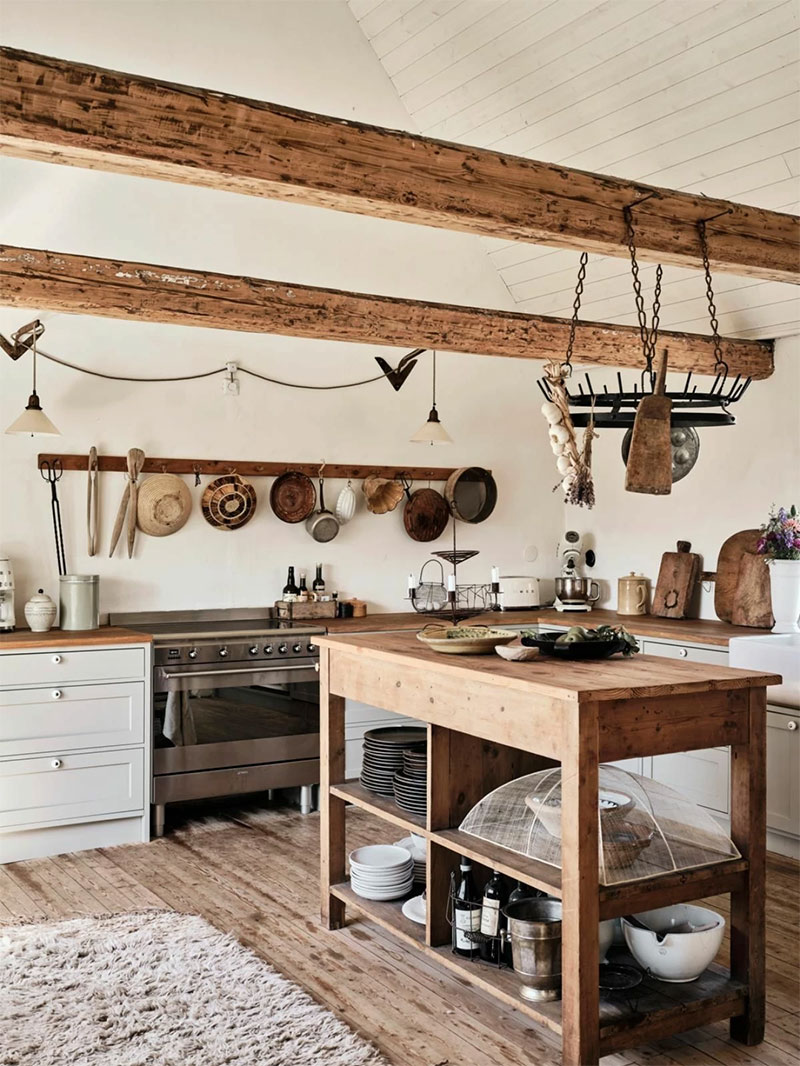Une cuisine rustique de style Scandinave Une cuisine rustique de style Scandinave où le bois brut du plancher et des poutres est contrebalancé par le blanc
