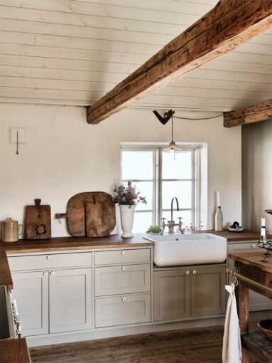Une cuisine rustique de style Scandinave Une cuisine rustique de style Scandinave où le bois brut du plancher et des poutres est contrebalancé par le blanc