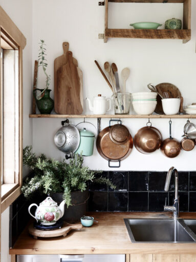 Mise en scène des ustensiles de cuisine suspendus et posés sur une étagère Mise en scène des ustensiles de cuisine suspendus et posés sur une étagère au-dessus du plan de travail