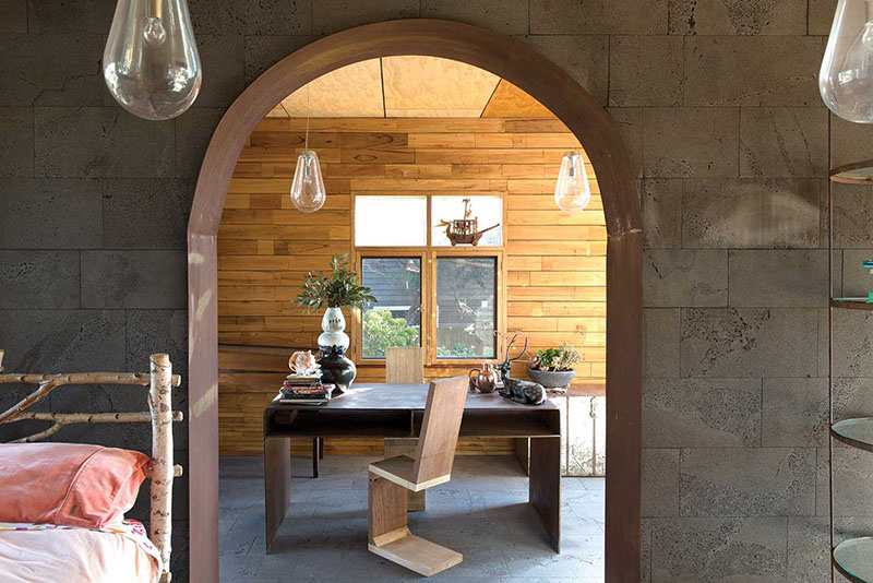 Une arche en bloc de béton ouvrant sur un coin bureau