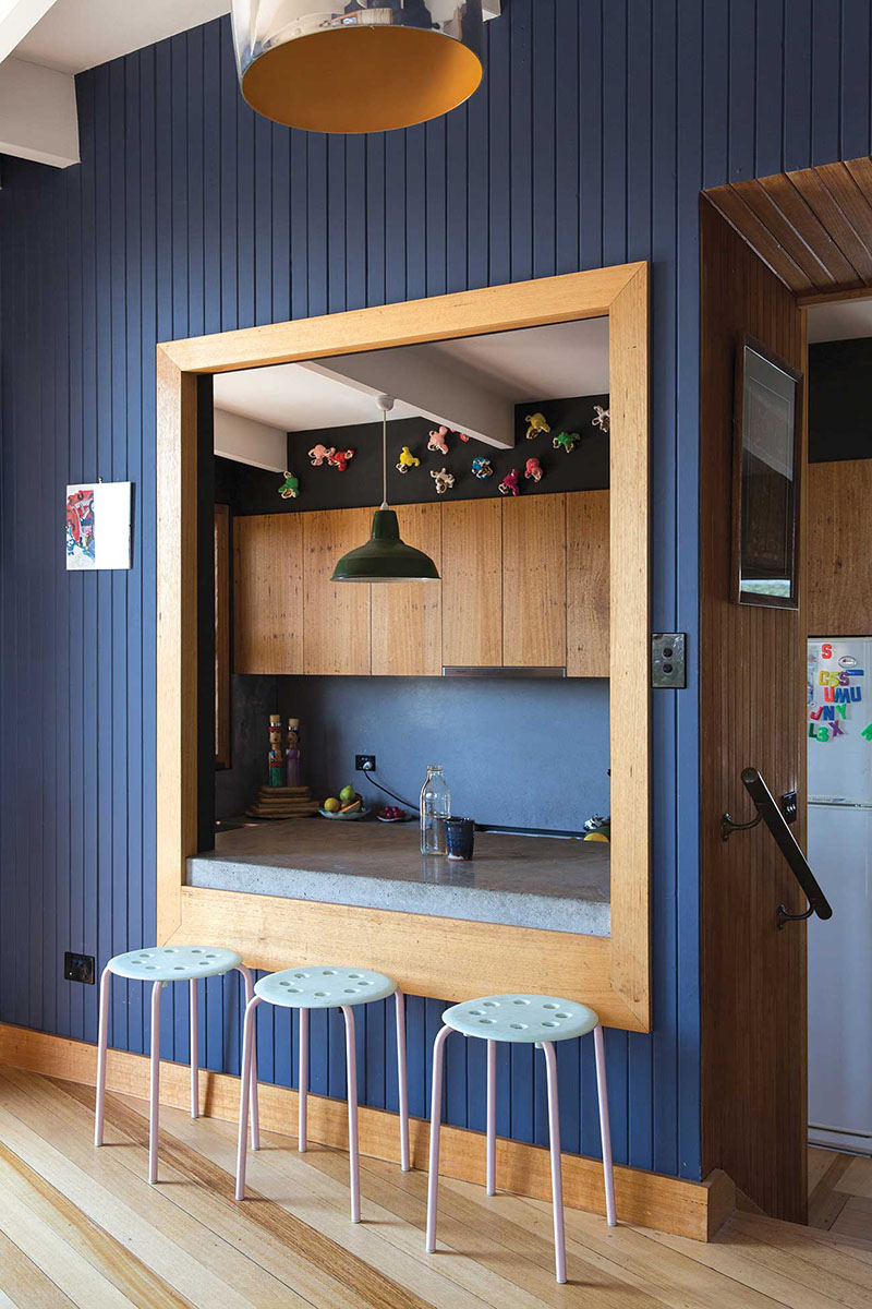 Une ouverture créée sur la cuisine au look vintage moderne avec son lambris peint en bleu
