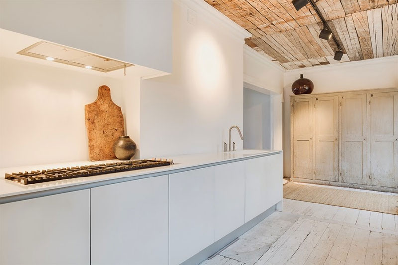 La cuisine contemporaine minimaliste réchauffée par les éléments en bois d'origine
