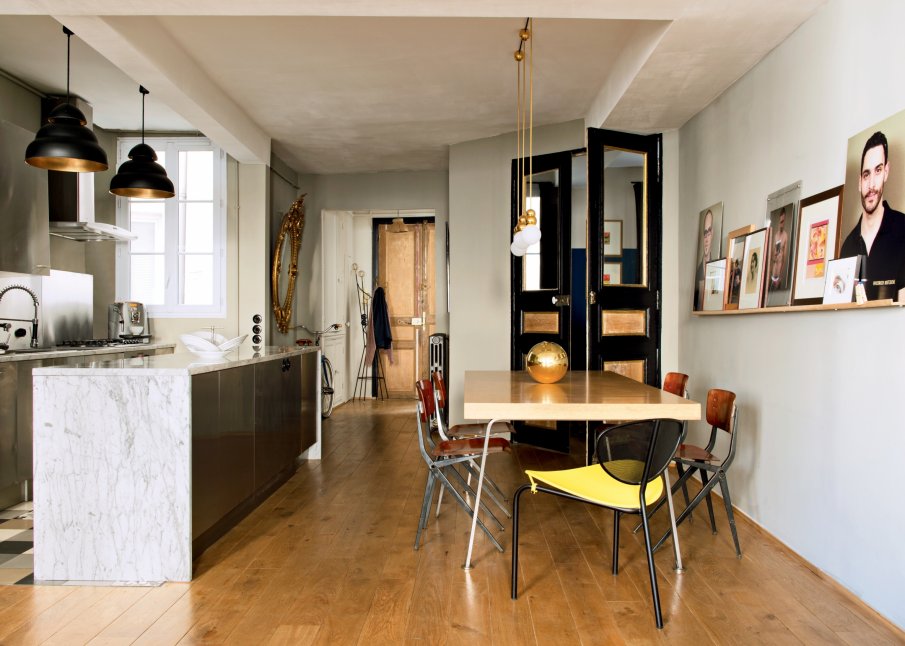 Une cuisine ouverte avec un ilot central en marbre pour cet appartment haussmannien