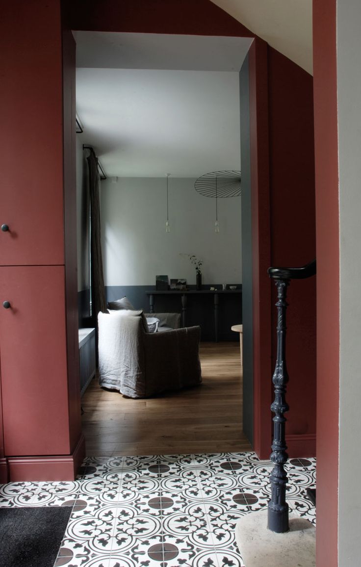 Une chambre aux murs dans un rouge sombre, soulignée d'un trait noir