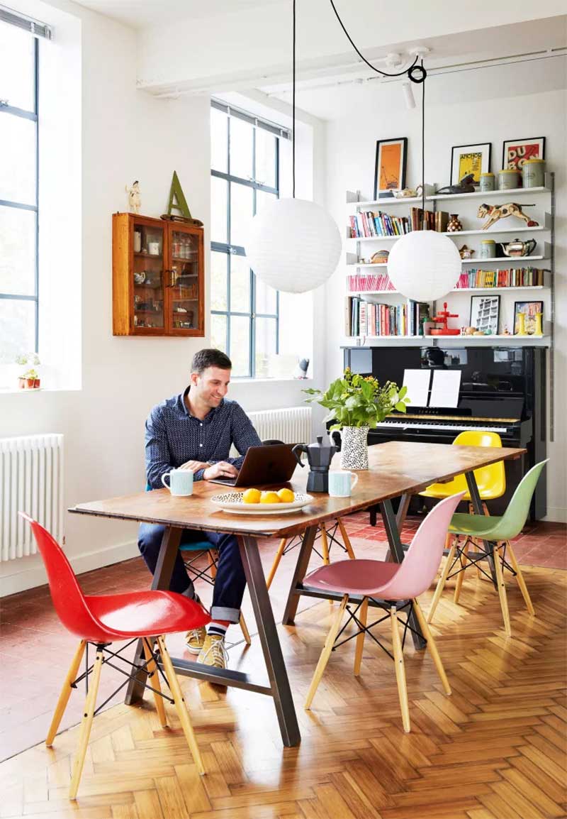 Coin repas avec des chaises dépareillées Eames de toutes les couleurs