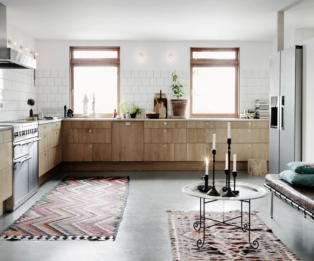 Une cuisine minimaliste en bois, ciment et faïences blanches dans une maison scandinave