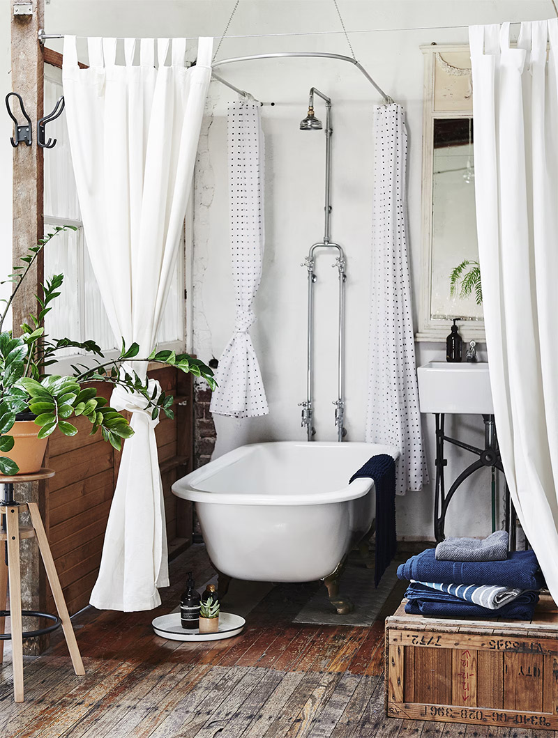 Un espace salle de bains, mis en scène dans un loft industriel ouvert, dans un style brocante assumé