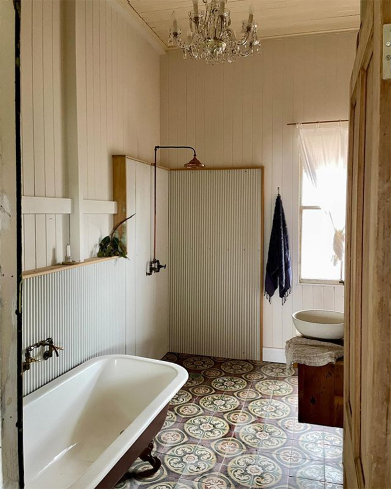 Salle de bains dans un esprit château avec lustre et robinetterie antique