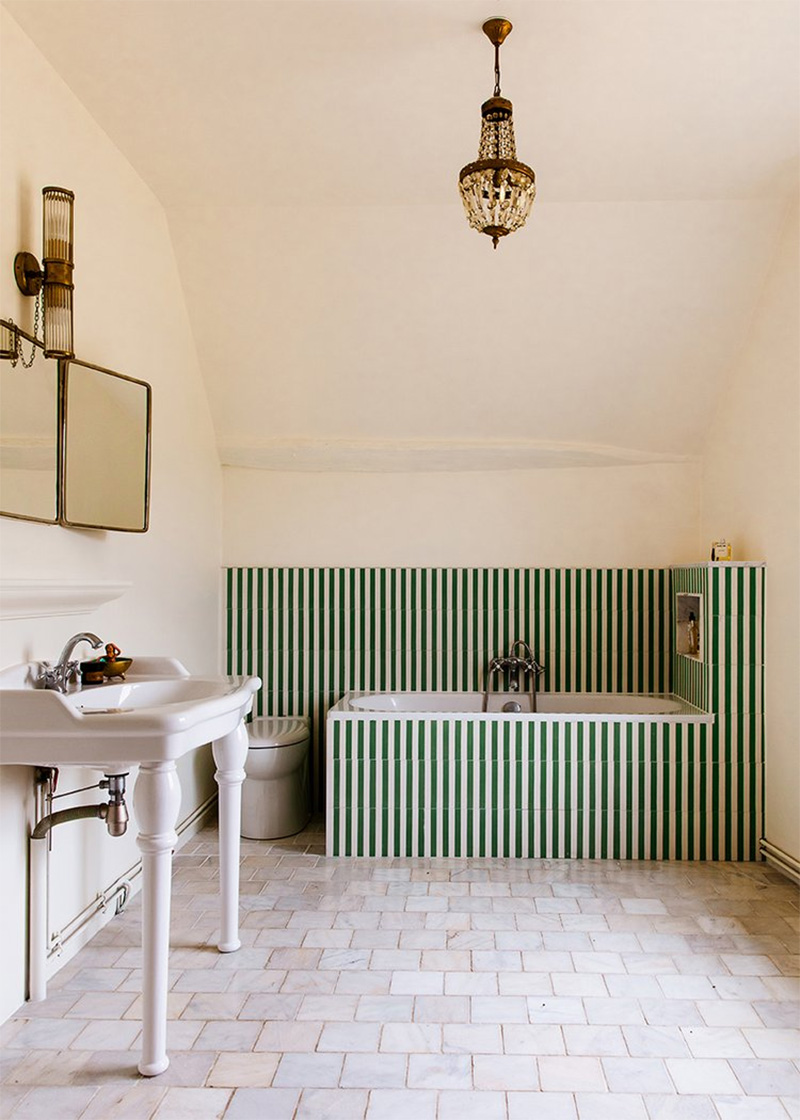 Salle de bains de campagne minimaliste, réveillée par un carrelage à rayures blanc et vert autour de la baignoire
