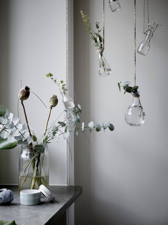 Vases suspendus avec des branches de plantes