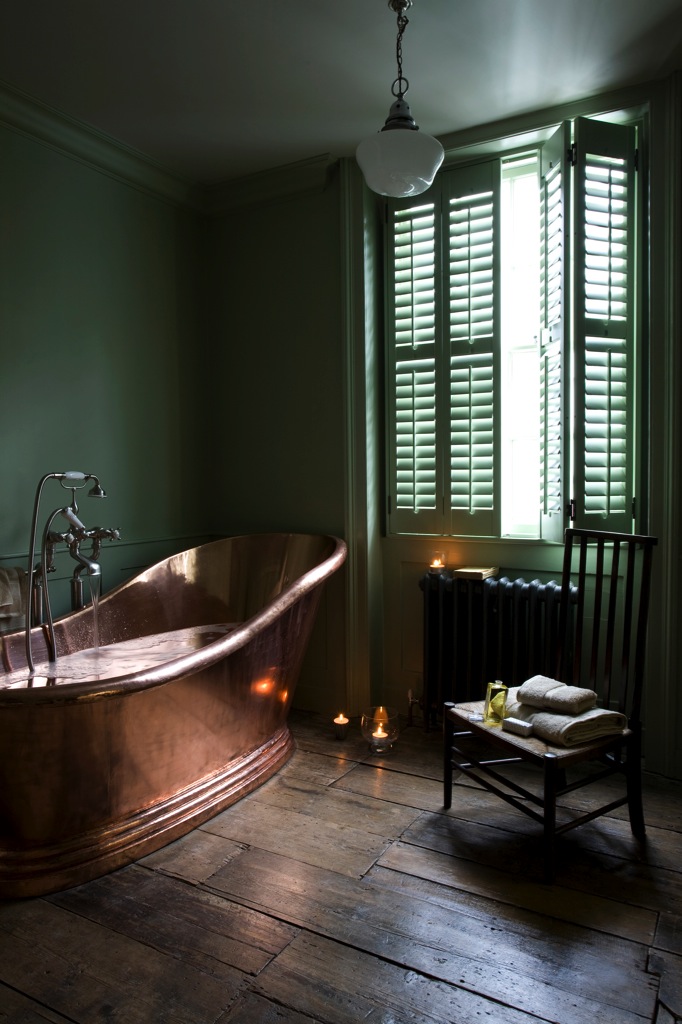 Salle de bain Shutters avec sa baignoire en cuivre et murs verts sapin