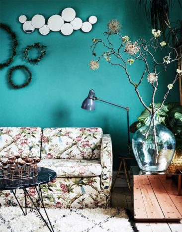 Un canapé fleurs classique réveillé par un mur peint en turquoise et du mobilier design