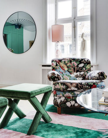 Un fauteuil à motifs floraux réveillés par un tapis contemporain