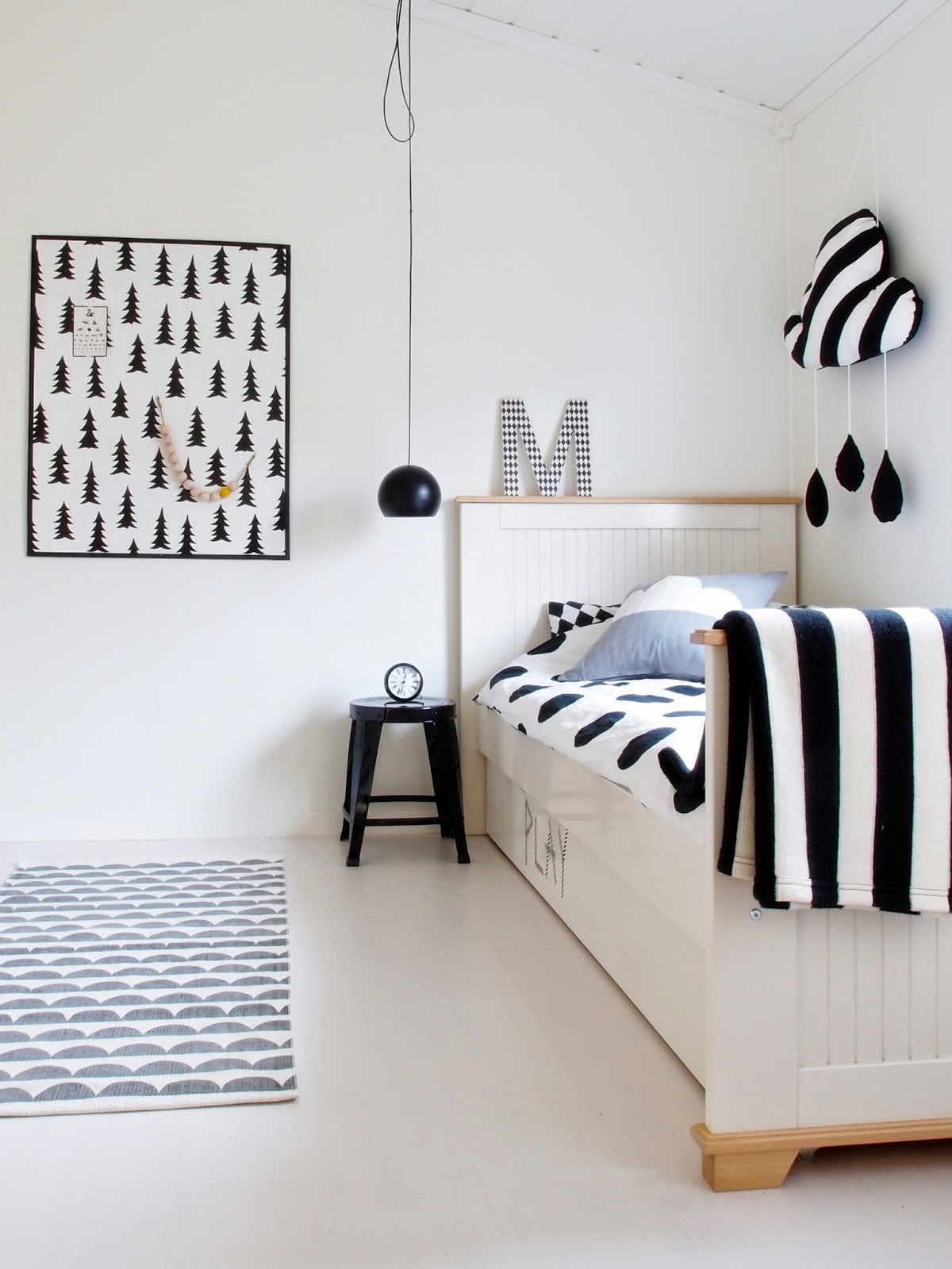 Chambre d'enfant blanche avec accessoires en noir et blanc