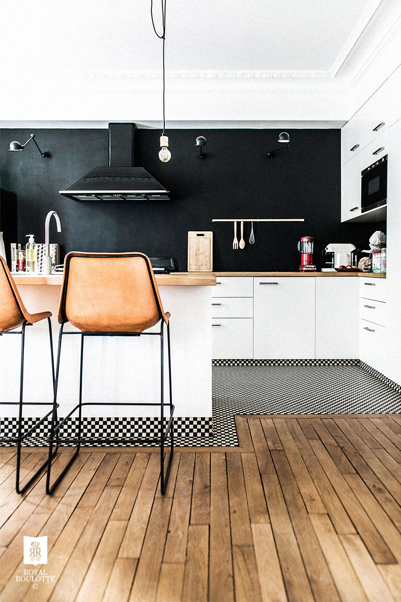 Une cuisine en noir et blanc graphique avec plan de travail en bois