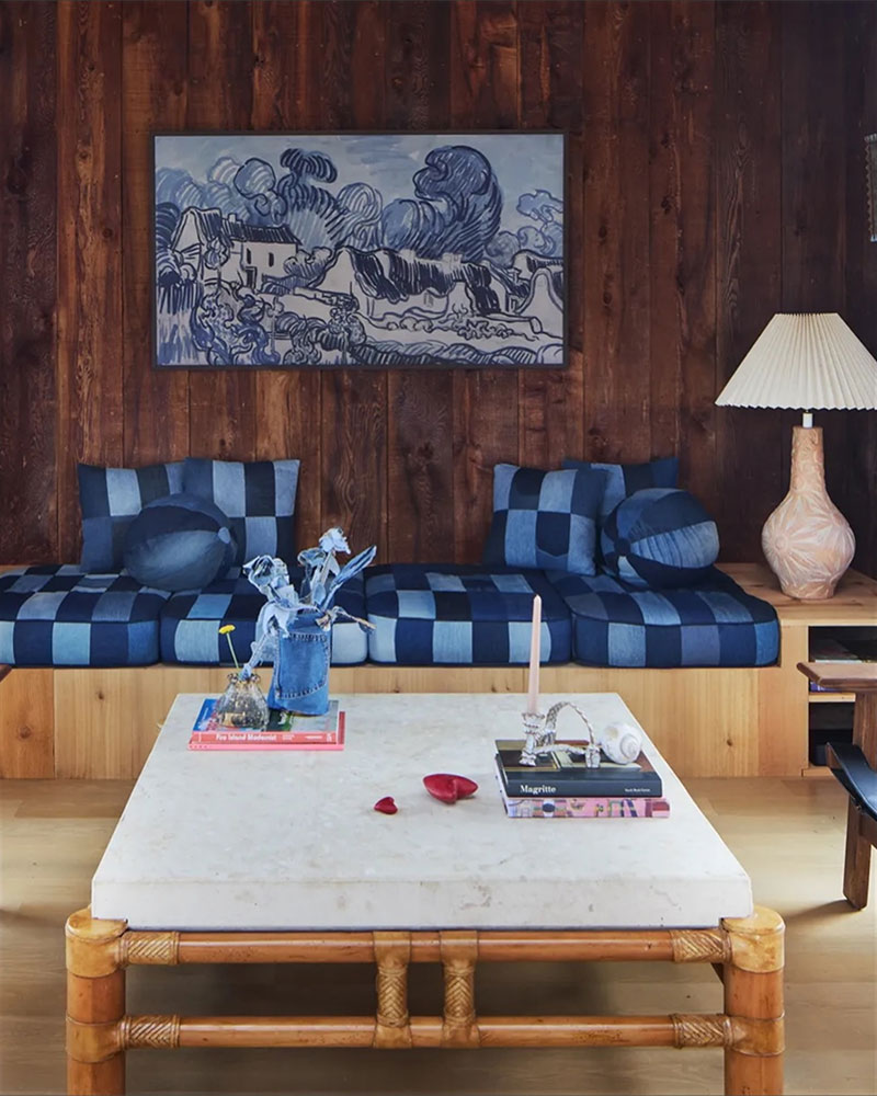 Maison californienne en bord de côte avec ses murs en bois teintés et sa banquette avec des coussins en shibori