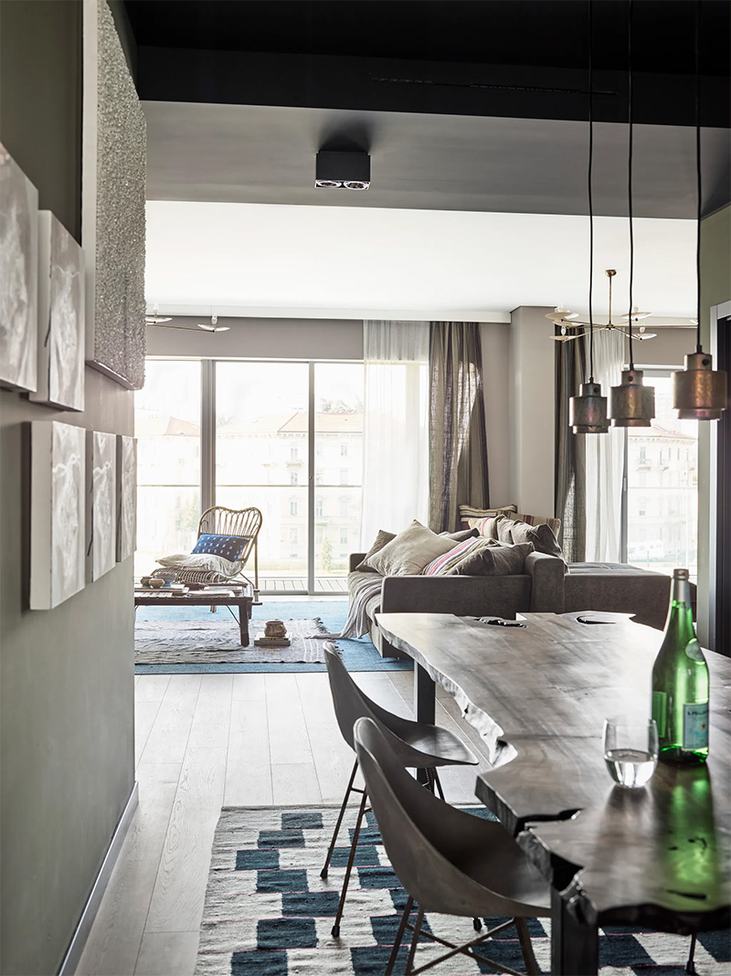 Un appartement contemporain avec des tapis superposés pour réchauffer l'ambiance brute des matériaux et des lignes