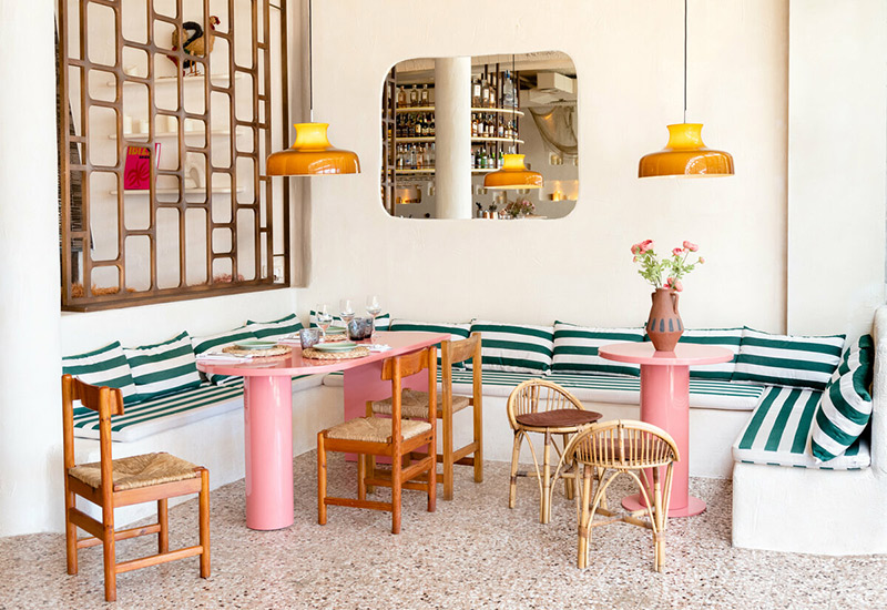 Une salle à manger de restaurant qui mixe mobilier design et objets de brocante vintage Une salle à manger de restaurant qui mixe mobilier design et objets de brocante vintage