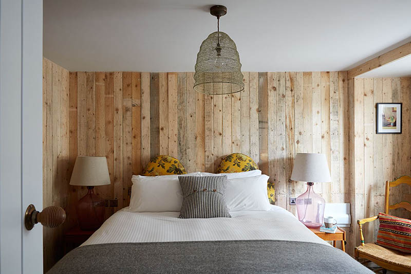 Une chambre avec un lambris réalisé avec des planches de bois récupérées