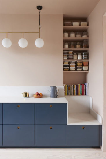 Une cuisine bleue dans un contexte rose blush par le studio Merlin