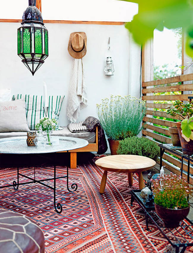 Une terrasse aménagée dans un style bohème avec des coussins et des tapis ethniques