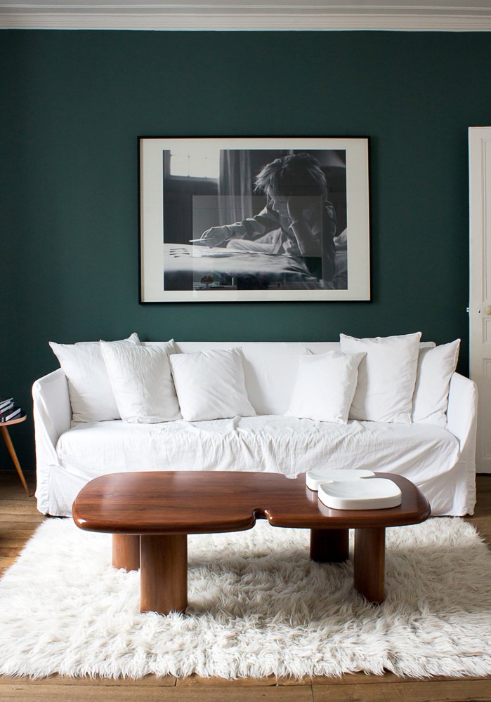 Canapé en lin blanc sur mur vert sapin pour une ambiance vintage revisitée