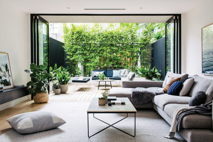 Salon de style contemporain avec une grande baie vitrée ouvrant sur un patio