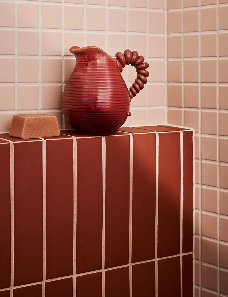 Une salle de bains avec du carrelage rose et bordeaux par Kim Kneipp Une salle de bains avec du carrelage rose et bordeaux par Kim Kneipp