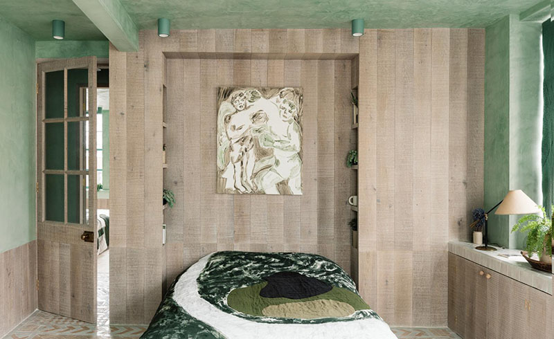 La chambre avec son placard aménagé autour du lit en bois brut