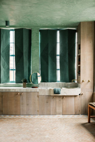 The Beldi par le studio Chan & Eayrs, salle de bains vert d'eau, bois brut et briques