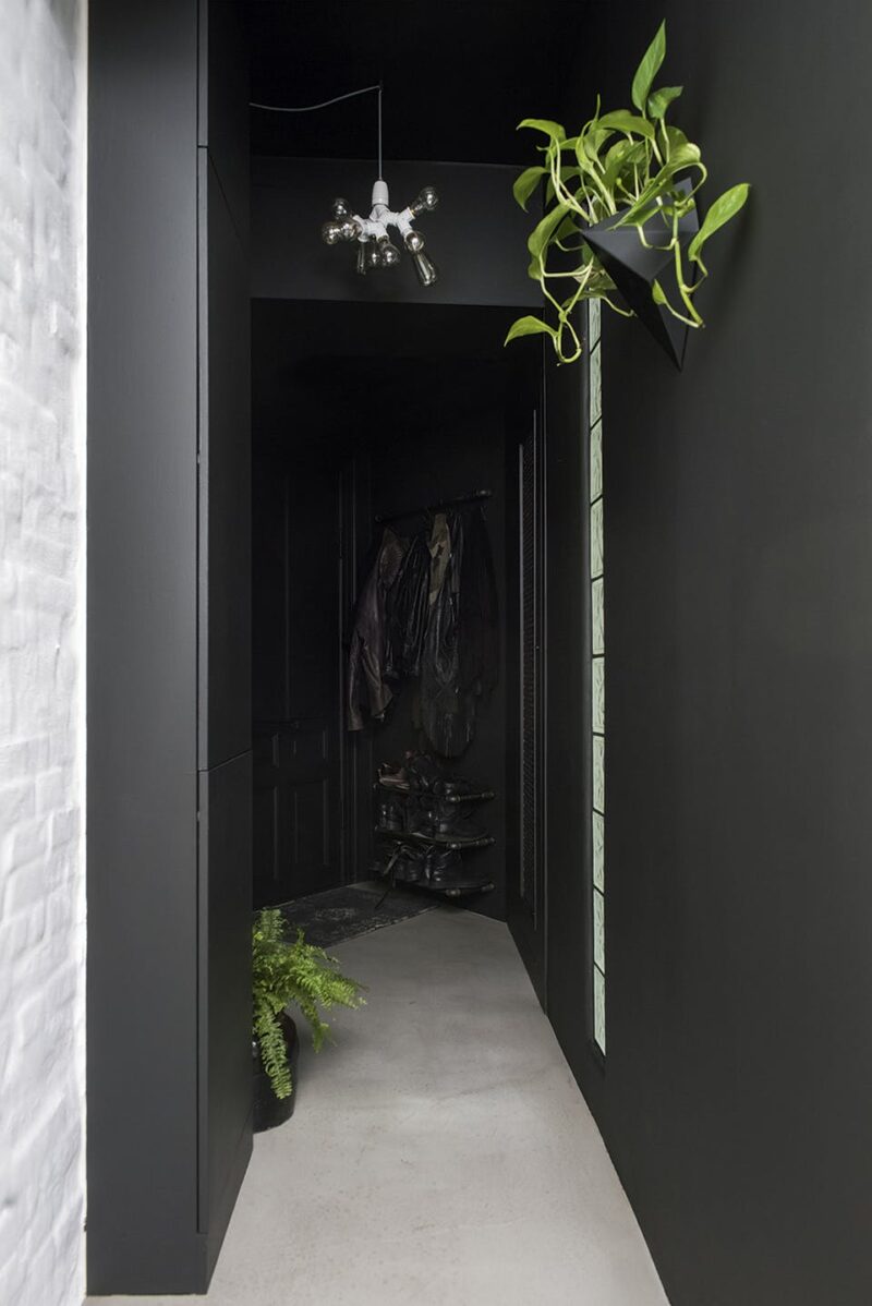 Peindre sa porte d'entrée de la même couleur que les murs pour la fondre avec le décor, ici du noir absolu