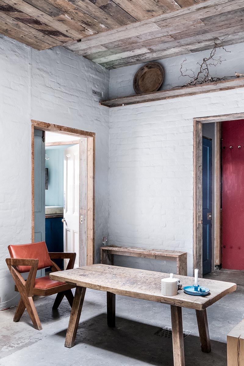 Un espace salon rustique, laissé dans son jus et aménagé de façon sommaire avec du mobilier de brocante // The Coach house - Queen Anne road, London E9