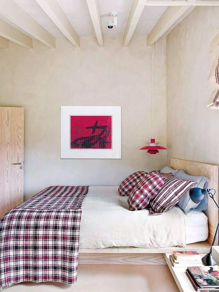 Chambre minimaliste dans un camaïeu de tonalités beiges, réveillées par des touches de rouge