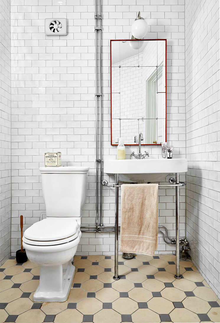 Salle de bains de style "Art déco" et ses toilettes placées à l'angle de la pièce près de la vasque Salle de bains de style "Art déco" et ses toilettes placées à l'angle de la pièce près de la vasque