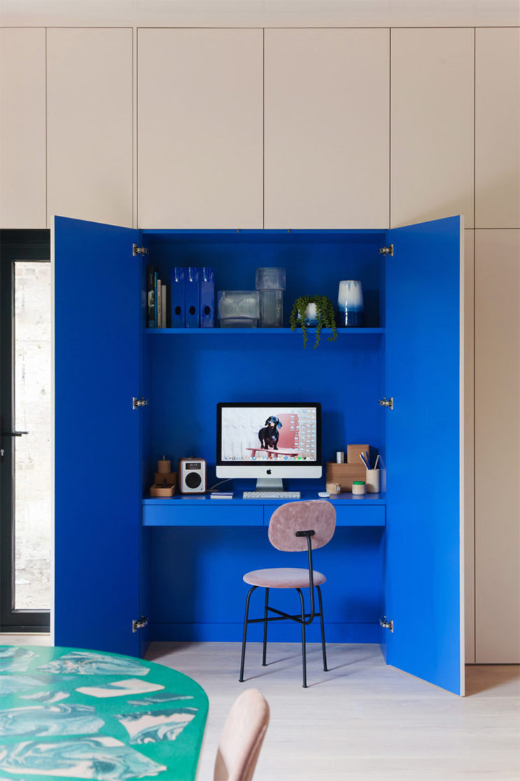 Un coin bureau aménagé dans un placard et peint en bleu électrique