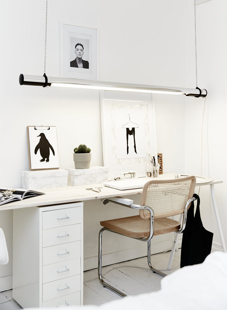 Un bureau blanc de style scandinave, éclairé par un néon